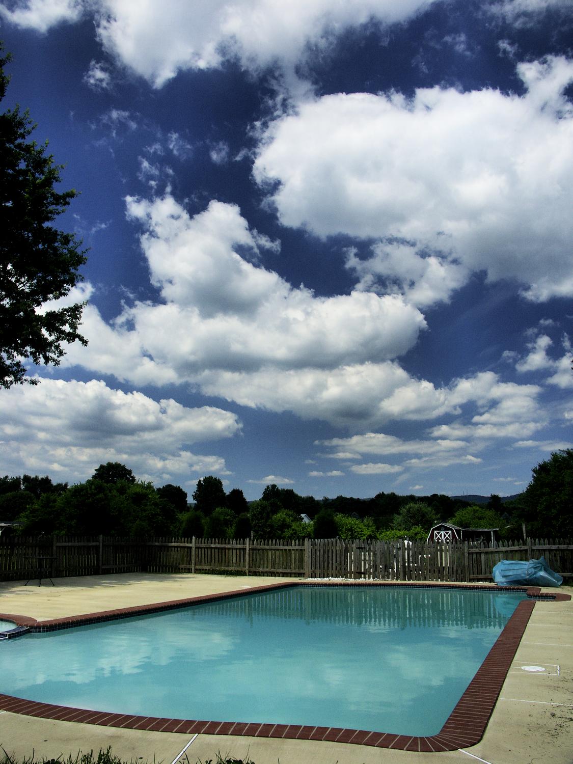 a swimming pool with clouds in the background - A dramatic shot of the pool that came with the house - Tony Karp, design, art, photography, techno-impressionist, techno-impressionism, aerial photography , drone , drones , dji , mavic pro , video , 3D printing - Books -