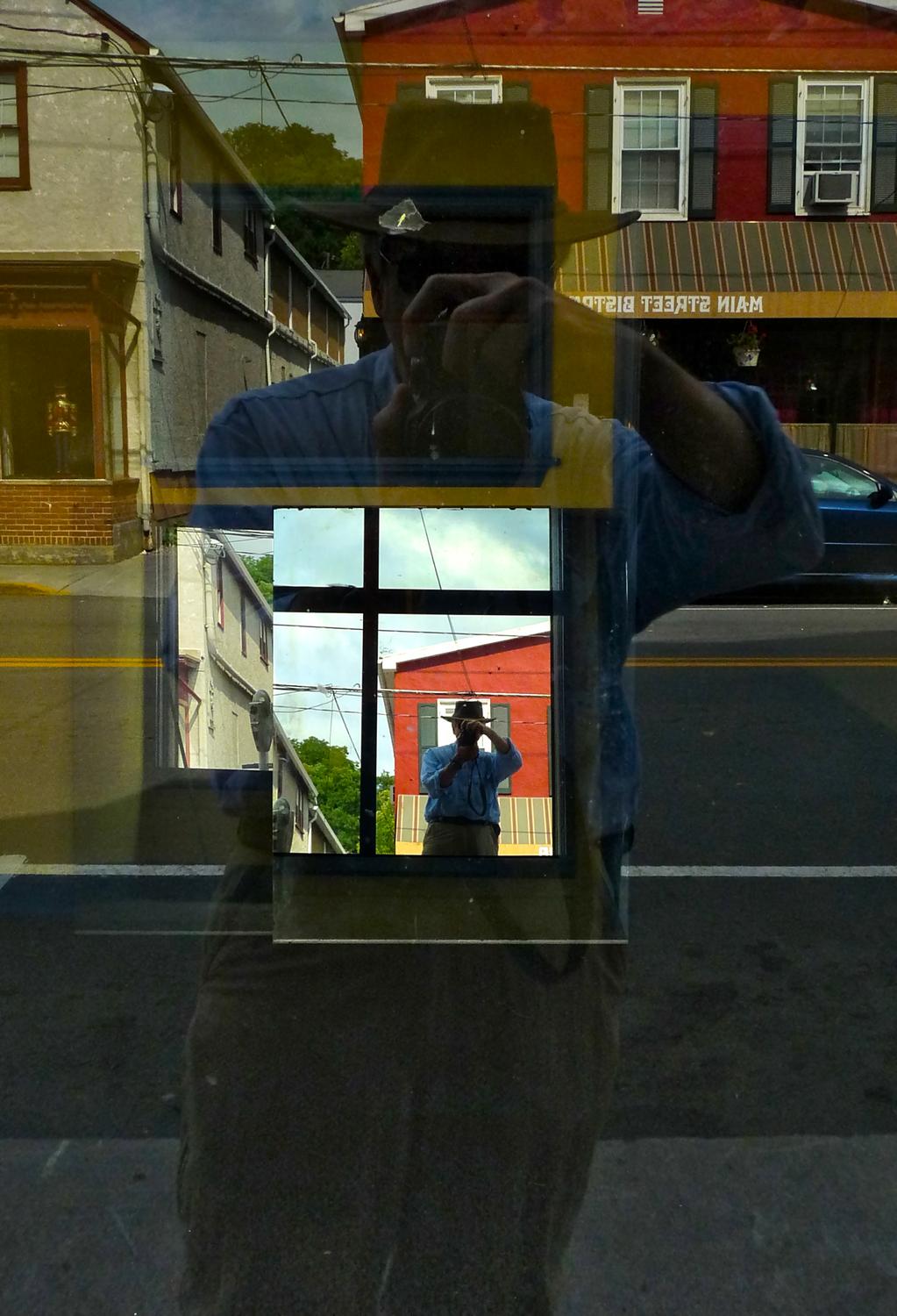 a reflection of the artist in a mirror in a store window - The spirit of Ren Magritte visits Berryville - Berryville Virginia - Panasonic DMC-FZ28 - Tony Karp, design, art, photography, techno-impressionist, techno-impressionism, aerial photography , drone , drones , dji , mavic pro , video , 3D printing - Books -