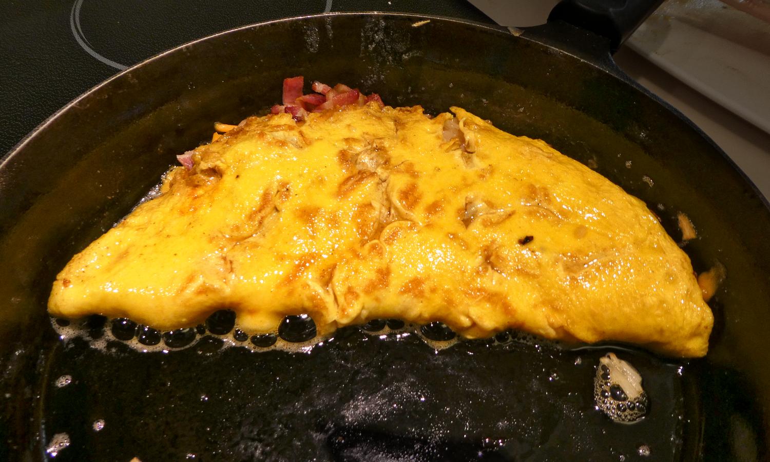  - In the pan, the omelette has just been folded over. Lots of butter makes the omelette richer.<br>Notice the deep yellow of the home-grown eggs. - Mark and Lana -- Chickens -- Eggs -- eggshells -- green eggs and ham - - Tony Karp, design, art, photography, techno-impressionist, techno-impressionism, aerial photography , drone , drones , dji , mavic pro , video , 3D printing - Books -